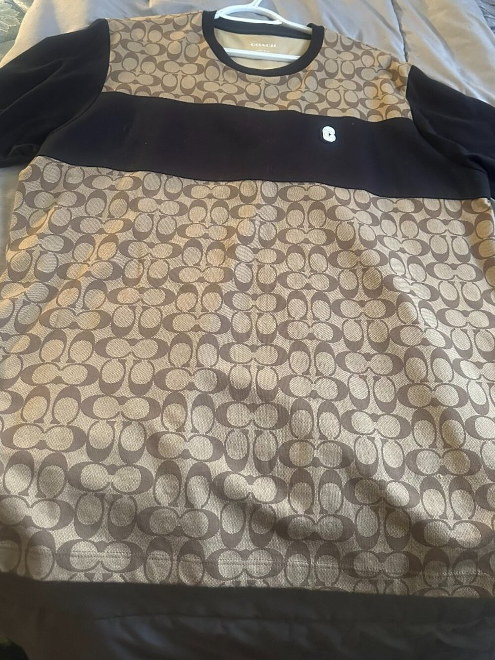 Authentic Coach polo featuring signature C jacquard in tan and black.